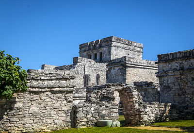 Low angle view of old ruin against clear blue sky