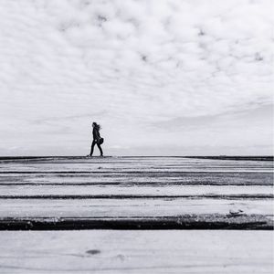 Full length of woman walking on pier against sky