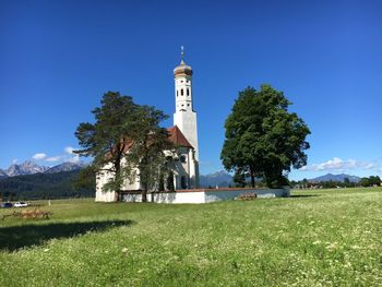 Church on grassy field against sky