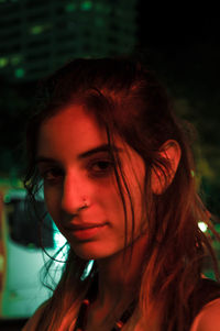 Close-up portrait of young woman at night