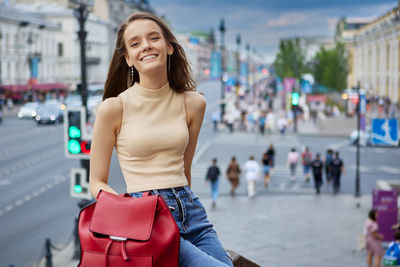 Portrait of a smiling young woman in city