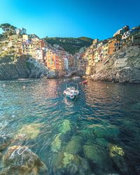 Scenic view of sea by buildings against clear blue sky