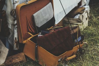 High angle view of open leather suitcase on field