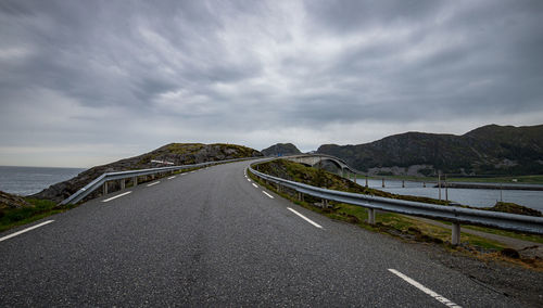 Surface level of road by sea against sky