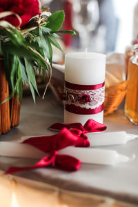 Close-up of candles tied with red ribbons on table