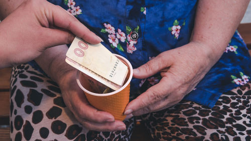 Midsection of woman holding money