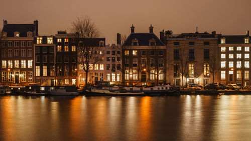 Reflection of buildings in river at sunset