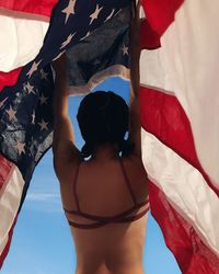 Rear view of woman standing at beach