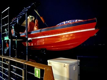 Red boats moored in illuminated at night