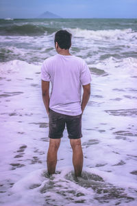 Rear view of man standing at beach