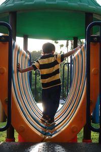 Thailand boy wearing striped shirt, playing in the park, taking photos backlit