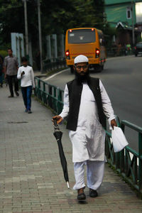 Man walking on footpath in city