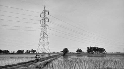 Electricity pylon on field against sky