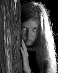 Portrait of girl by tree trunk