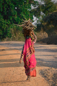 Rear view of woman walking on road