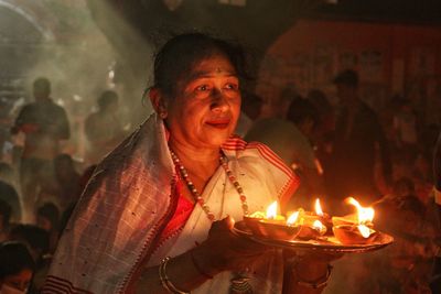 Women holding dia-oil lamp on hand at a smokey environment at rakher upobash 