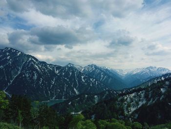 Scenic view of mountains against cloudy sky