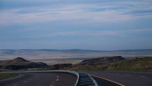 Road leading towards mountain against sky