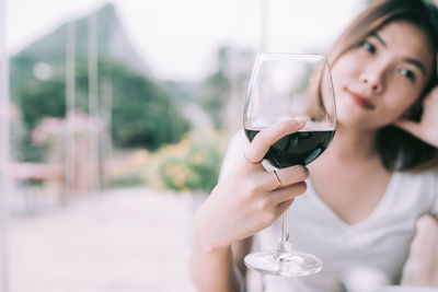 Woman looking away while holding wine in glass