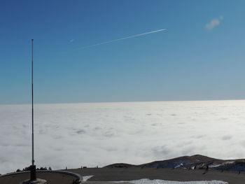 Scenic view of sea against vapor trail in sky