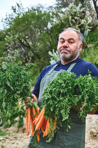 Ripe natural organic freshly picked carrots in the hands of farmer. harvest agriculture concepts.