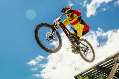 Low angle view of man riding bicycle against sky