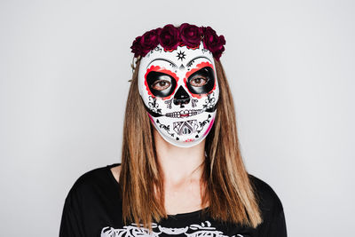 Portrait of woman wearing mask against white background