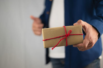 Midsection of man holding paper in box