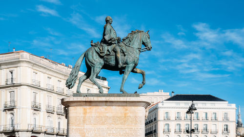 Statue against sky in city