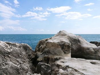 Scenic view of rocks on beach against sky