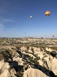 Hot air balloons flying over landscape