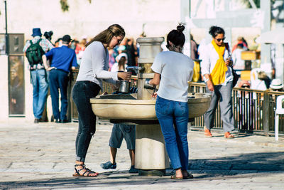 Group of people sitting on street in city