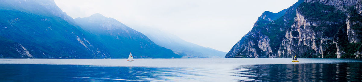 Scenic view of lake by snowcapped mountains against sky