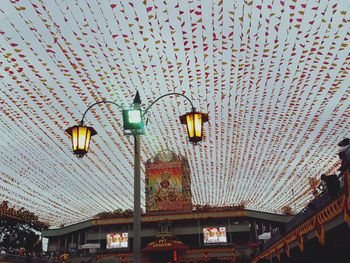 Low angle view of illuminated lanterns hanging on wall