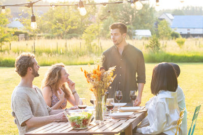 Portrait of smiling friends sitting on table