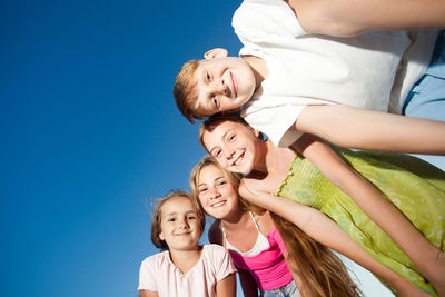 Portrait of smiling girl against blue sky