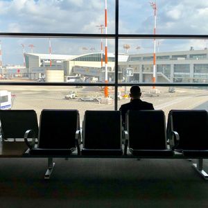 Rear view of man sitting at airport