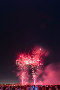 Low angle view of firework display at night
