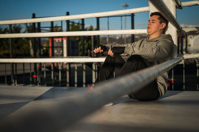 Rear view of man standing on railing