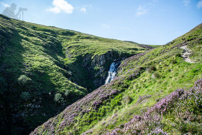 Scenic view of waterfall against sky