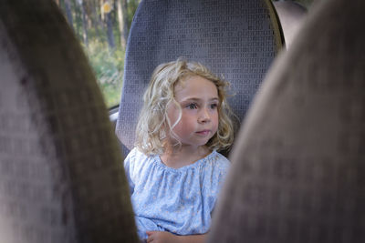 Portrait of cute girl against tree trunk