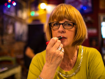 Portrait of woman applying lipstick