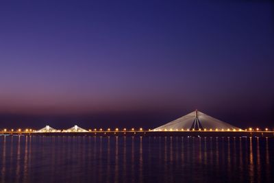 Illuminated bandra–worli sea link over sea during sunset