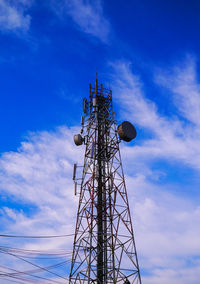 Low angle view of communications tower against blue sky