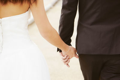 Midsection of couple holding hands