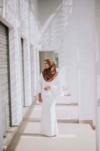 Young woman standing in building corridor