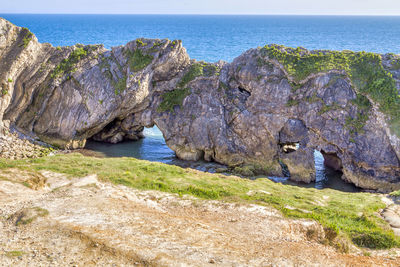 Scenic view of rocks on beach against sky