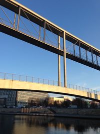Low angle view of bridge over river against clear sky