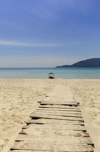 Scenic view of beach against clear blue sky