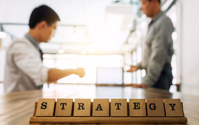 Closed of strategy text with businessmen in background